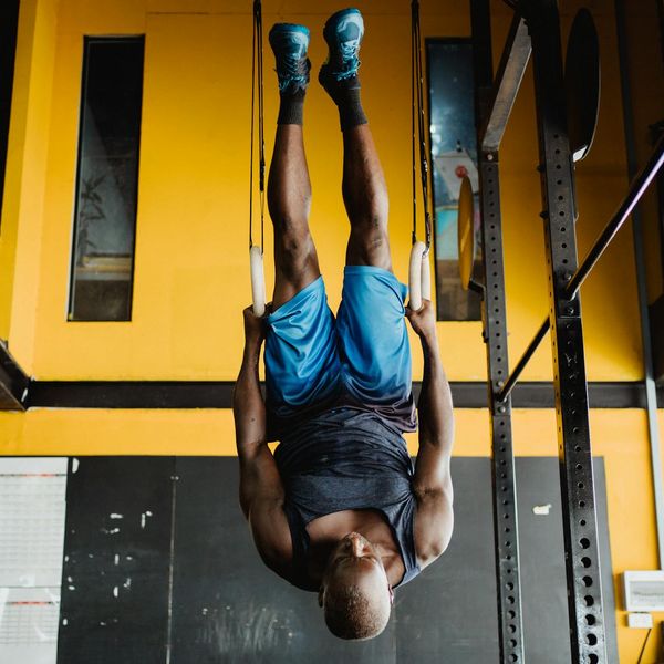 Man performing a controlled strength exercise in a modern, minimalist gym.